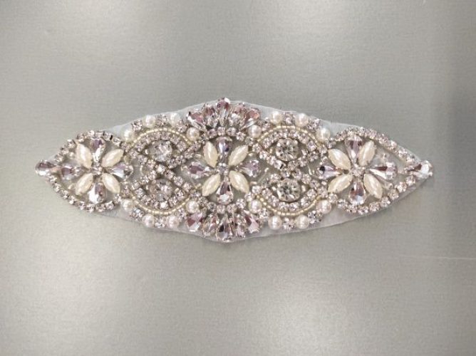 Kristályokkal és gyöngyökkel díszített motívum. Mérete: 5 x14,5 cm.

Kristályok ezüst színűek

Felvasalható.